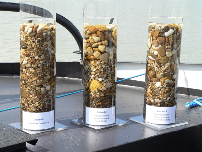 Diese drei Behälter zeigen, wie sich die GSV auf die Zusammensetzung der Donau-Sohle auswirken soll: Links ist der Ausgangszustand des Bodenmaterials zu sehen. In der Mitte wurde oben gröberer Kies zugegeben. Auf dem rechten Bild haben sich der originale und der zugefügte Kies miteinander vermischt. 
