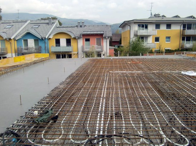 Dieses Bild zeigt, wie das Rohrleitungssystem für die bauteilaktivierte Betondecke im Gemeindezentrum Rif verlegt wird.
