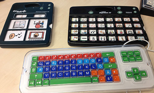 Komplexeres Sprachausgabegerät (re.). Unten: Tastatur mit Raster, das das gezielte Drücken von Tasten erleichtert.
