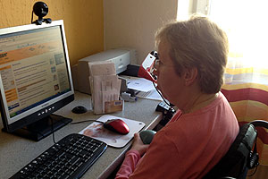 Karin Sieber an ihrem Computer. Sie surft im Internet mit ihrer Mundmaus. Karin Sieber an ihrem Computer. Sie surft im Internet mit ihrer Mundmaus.
