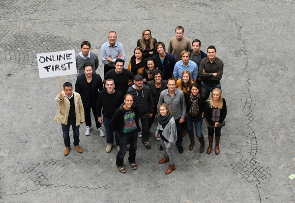 Das junge Team demonstriert mittels selbst gemaltem Schild seine journalistische Geisteshaltung: "Online First".