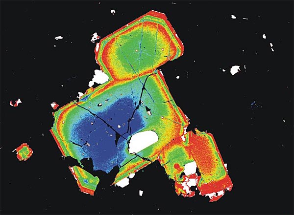Falschfarbenbild von sogenannten Orthopyroxen-Kristallen aus dem Magma, die die Forscher in der forensischen Analyse des Mount St. Helens-Ausbruchs 1980 verwendeten. Die unterschiedlichen Farben spiegeln unterschiedliche chemische Zusammensetzungen wider. Gelb stellt etwa eine besonders eisenreiche Zone dar.