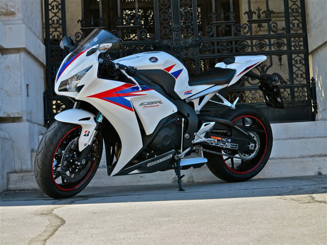 Honda Fireblade CBR 1000 RR
Motor: 4 Zylinder-4-Takt-Motor, 16 VentileHubraum: 999 ccmLeistung: 131 kW (178 PS) bei 12.000 U/minDrehmoment: 112 Nm bei 8.500 U/minKraftübertragung: 6 Gang, KetteRadaufhängung vorne: 43 mm USD-Teleskop-GabelRadaufhängung hinten: Unit Pro-Link-System, Balance Free Rear CushionBremse vorne: Doppel-Scheibenbremse, Ø 320 mm, 4-Kolben, (optional C-ABS)Bremse hinten: Scheibenbremse, Ø 220 mm, 1-Kolben, (optional C-ABS)Reifen vorne: 120/70 ZR17M/CReifen hinten: 190/50 ZR17M/CGewicht vollgetankt: 200 kg (211 kg mit C-ABS)Sitzhöhe: 820 mmPreis: ab 16.490 Euro (Aufpreis C-ABS: 1.200 Euro)
+ Fescher Supersportler, der nicht nur auf der Rennstrecke eine gute Figur macht, sondern auch bei der gehetzten Tour.
- Für den Sieg auf der Rennstrecke fehlen ihr ein paar Pferde und die Traktionskontrolle.