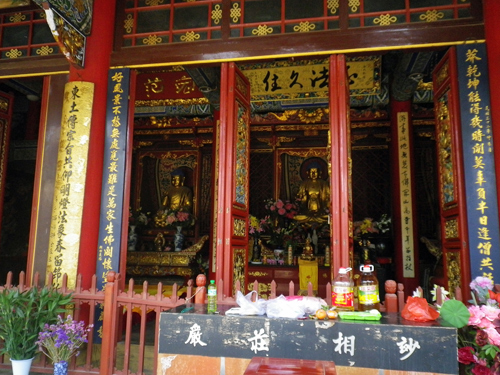 Buddhastatue mit Gaben der Gläubigen.