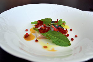 Schellfisch-Sashimi mit wildem Löwenzahn, Blüten und rosa Pfeffer.