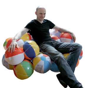 ...und ein Spontan-Sofa aus aufblasbaren Bällen, wie man sie sonst eher am Badestrand findet. Darauf lümmelt sein Erschaffer. ...und ein Spontan-Sofa aus aufblasbaren Bällen, wie man sie sonst eher am Badestrand findet. Darauf lümmelt sein Erschaffer.